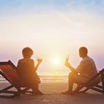 A couple on the beach at sunset sitting in beach chairs