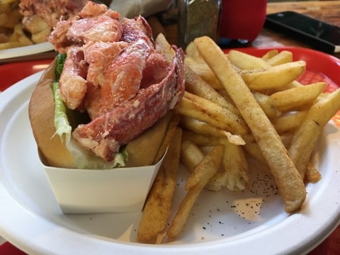 a plate with a lobster roll and french fries
