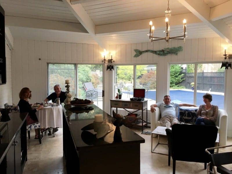 Photo of the Lounge with a couple on the couch and another couple having breakfast at a table.