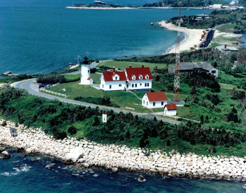 View from the sky of the shoreline and the red and white Nobska Lighthouse
