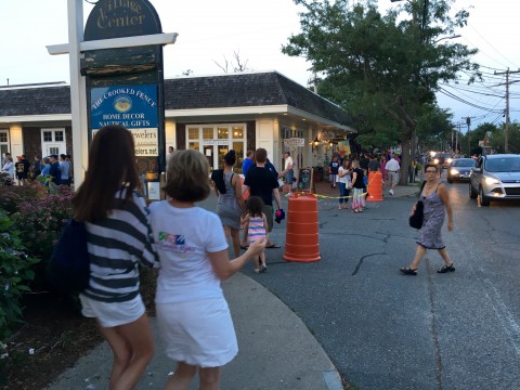 Downtown Harwich Port at night.  People are walking along the streets and by shops