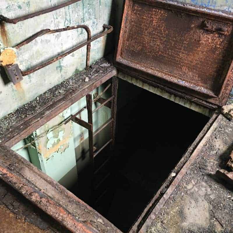 A rusty hatchway inside an old building