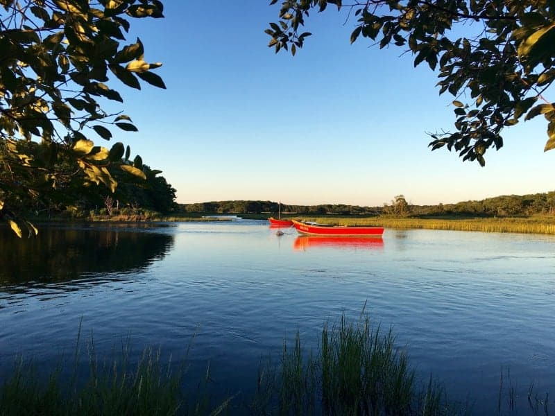 A salt water estuary with 2 red boats in the water