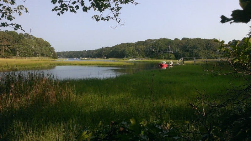 A salt water estuary with a red boat in the water