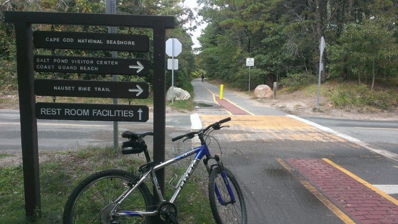 a bike sitting by a sign on the cape cod rail trail