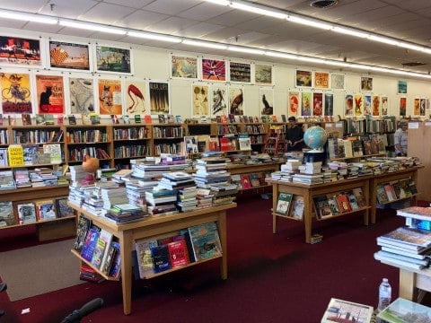 inside a bookstore with tables and shelves full of books