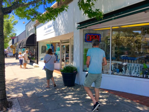 people walking by a store front