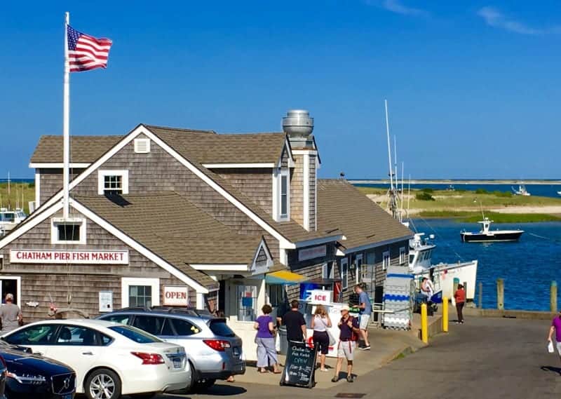 photo of the Chatham Fish Pier by the ocean in Chatham with many people and cards