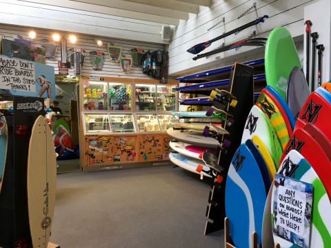 inside a store selling colorful surf boards