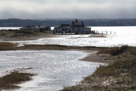 a house on a peninsula in the ocean in the fall on a grey overcast day