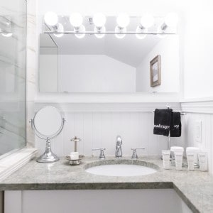 whie bathroom with a hollywood mirror and lighting