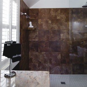 A brown tiled walk in shower