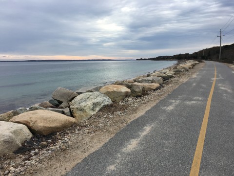 photograph of the shining sea bike path that hugs the ocean.  Large rocks are between the bike path and the ocean.