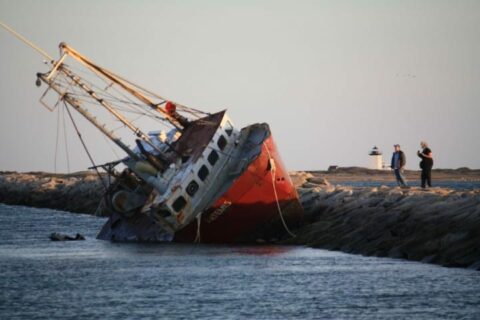 a boat wrecked upon a breakwall