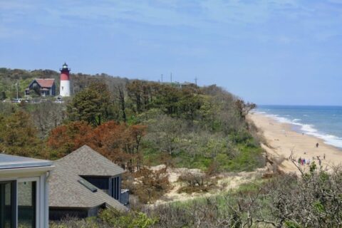 a beach and a red and white light house