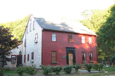 Exterior of Dillingham House, a red clapboard building with shrubs in front