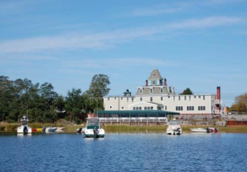 Exterior of the Orleans Inn as seen from the water.  Water and boats in the foreground