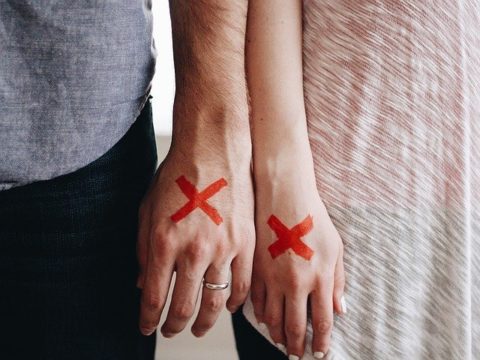a man and a woman's hand with an x drawn on them 