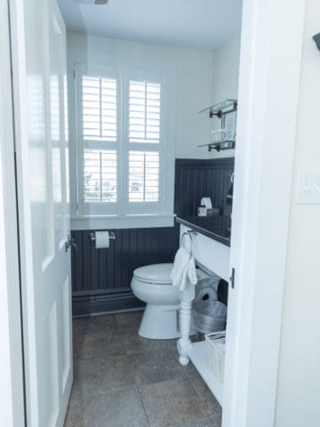 door open to a bathroom showing a shuttered window and toilet