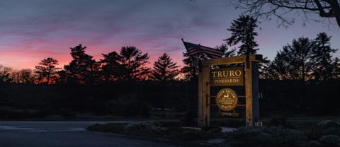 the truro vineyards sign in front of a sunset