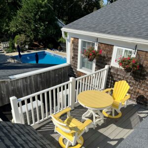 deck with yellow table and chairs overlooking the pool at the Platinum Pebble Boutique Inn