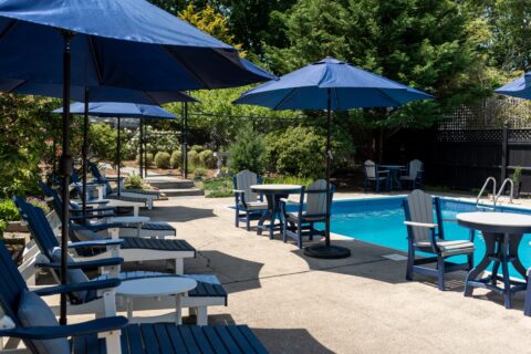 The pool area at The Platinum Pebble with sun loungers and umbrellas available