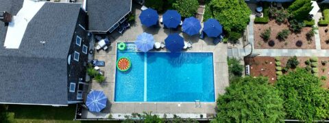 view from above of a pool with tables and umbrellas around it