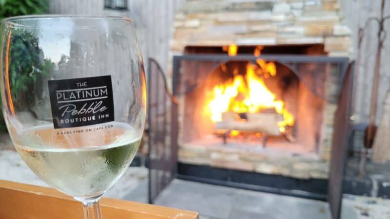 enjoying a glass of wine in a Platinum Pebble wine glass by the firepit in the garden